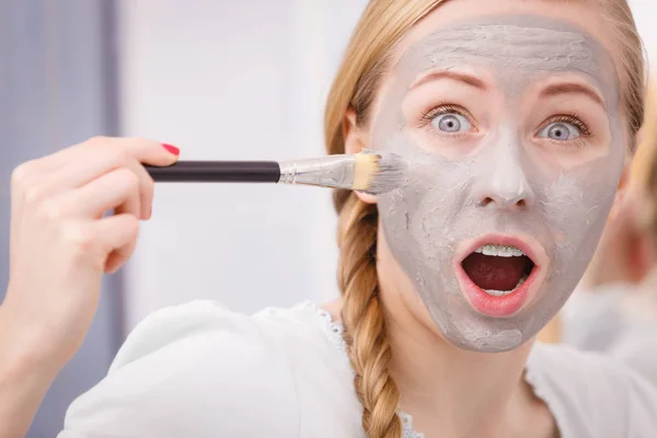 Kvinna som gäller med pensel lera lera mask för ansiktet — Stockfoto