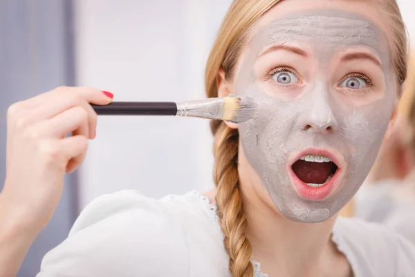 Femme appliquant avec un masque de boue d'argile brosse sur son visage — Photo