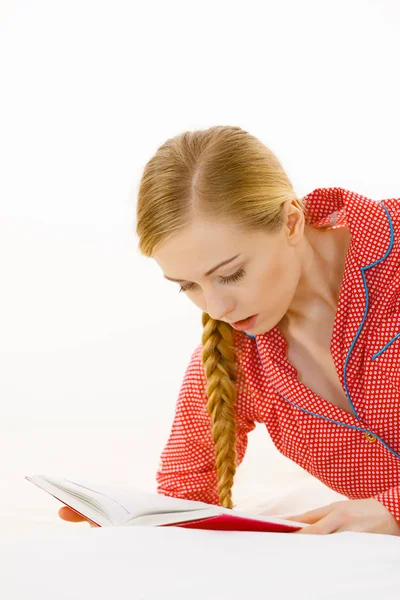 Frau entspannt sich im Bett beim Lesen von Buch — Stockfoto