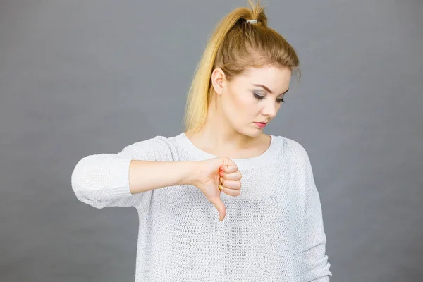 Mujer triste mostrando el pulgar hacia abajo gesto —  Fotos de Stock