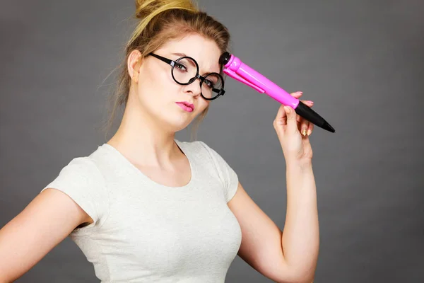 Mujer sosteniendo un gran lápiz de gran tamaño pensando en algo —  Fotos de Stock