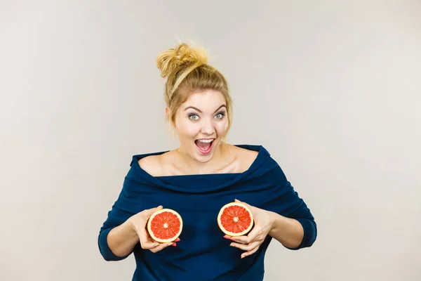 Frau mit roter Grapefruit auf Brust — Stockfoto