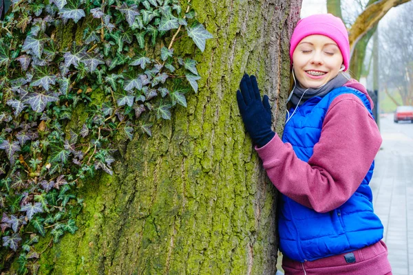 Mujer con ropa deportiva abrazando el árbol —  Fotos de Stock