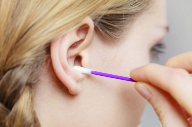 Woman cleaning ear with cotton swabs closeup clipart