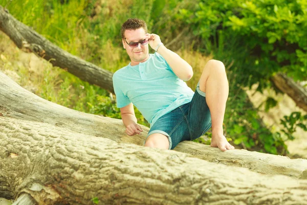 Knappe man ontspannen op het strand in de zomer. — Stockfoto