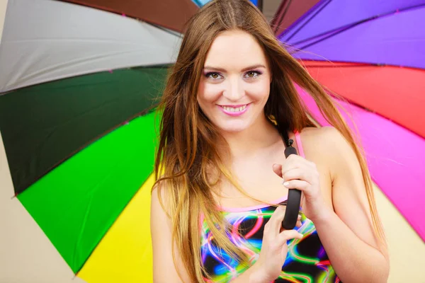 Lycklig kvinna poserar i baddräkt och färgglada paraply — Stockfoto