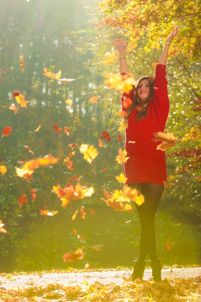 Radostné dívka se baví s listy v podzimní park. — Stock fotografie