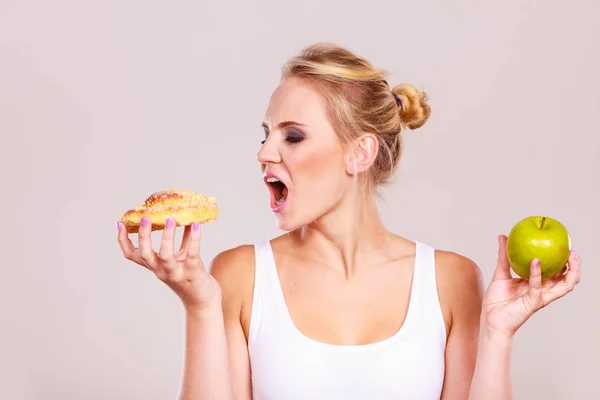 Femme tient gâteau et fruits à la main en choisissant — Photo