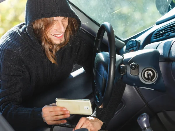 Hırsız araba çalıyor, akıllı telefon çalıyor. — Stok fotoğraf