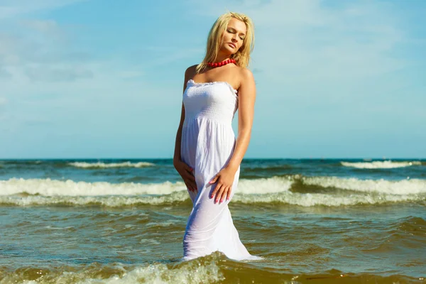 Blondine vrouw draagt jurk lopen in water — Stockfoto