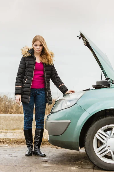 Blonde woman and broken down car on road — Stock Photo, Image
