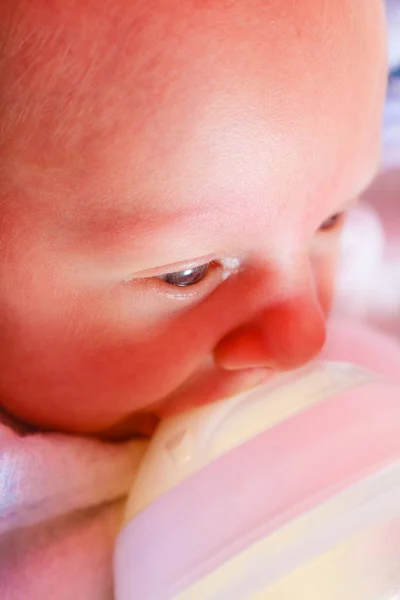 Маленький новонароджений їсть пиття з пляшки — стокове фото