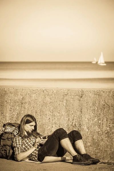 屋外のタブレットで座っている男観光バックパッカー — ストック写真