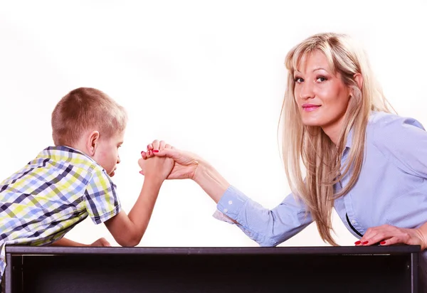 Mother and son arm wrestle sit at table. — Stock Photo, Image