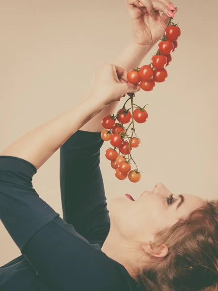 Mujer sosteniendo tomates cherry frescos — Foto de Stock