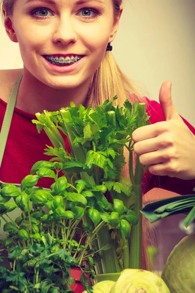 Mulher na cozinha com muitos vegetais verdes — Fotografia de Stock