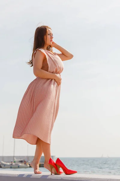 Vrouw lang licht roze jurk dragen op steiger — Stockfoto