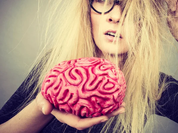 Mujer extraña sosteniendo el cerebro teniendo idea —  Fotos de Stock