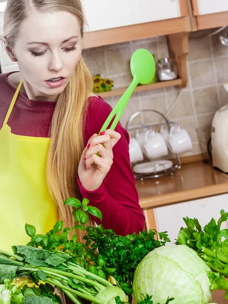 Vrouw met groene groenten denken over koken — Stockfoto