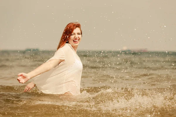 Roodharige vrouw spelen in water gedurende de zomermaanden — Stockfoto