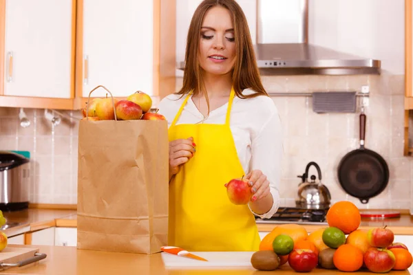 Mulher dona de casa na cozinha com muitos frutos — Fotografia de Stock