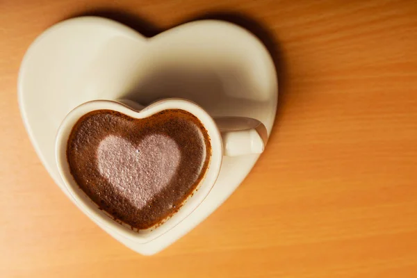 Kaffee in herzförmiger Tasse mit Liebeszeichen — Stockfoto