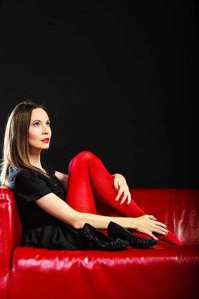 Mujer de moda en pantimedias rojas en el sofá — Foto de Stock