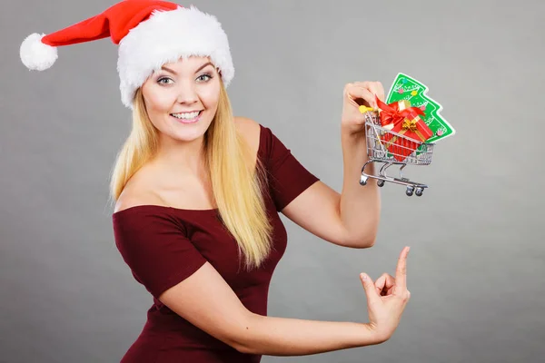 Santa woman holding shopping cart with christmas gifts — Stock Photo, Image