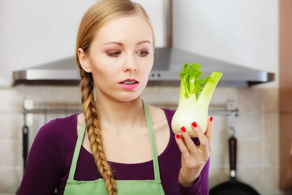 Женщина на кухне держит сырую луковицу фенхеля овощ — стоковое фото