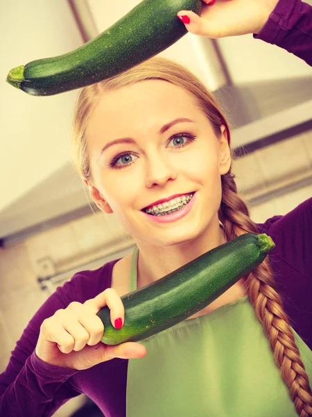 Mulher na cozinha detém abobrinha vegetal — Fotografia de Stock