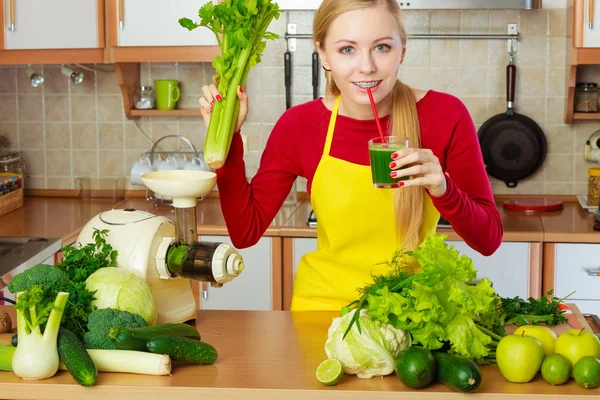 Woman in kitchen holding vegetable celery smoothie juice — Stock Photo, Image