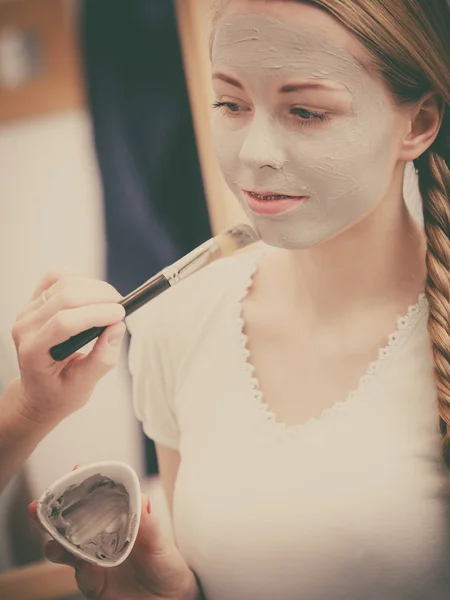 Woman applying with brush clay mud mask to her face — Stock Photo, Image