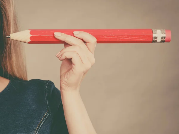 Female hand holds big red pencil — Stock Photo, Image