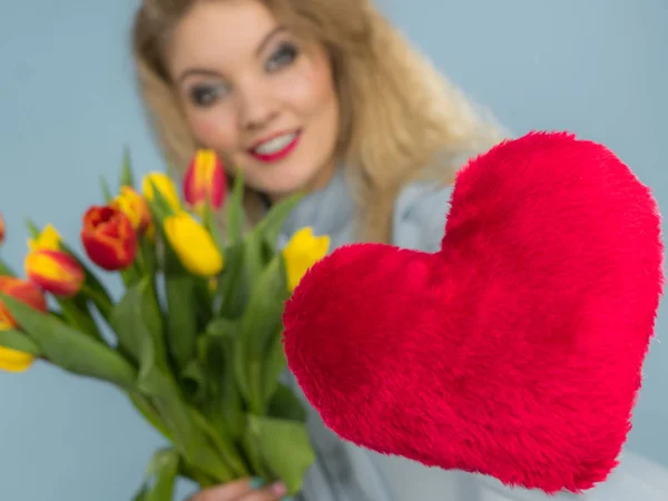 Mulher segura tulipas e coração vermelho — Fotografia de Stock