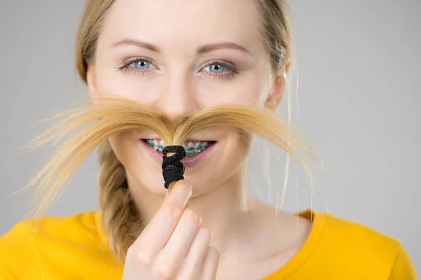 Kvinnan gör moustache ur blont hår — Stockfoto