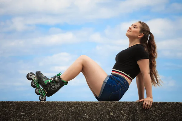 Šťastná mladá žena na kolečkových bruslích — Stock fotografie