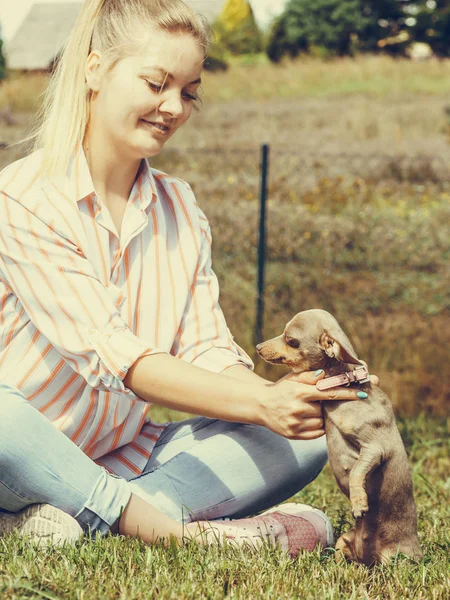 小さな犬を外で遊ぶ女性 — ストック写真