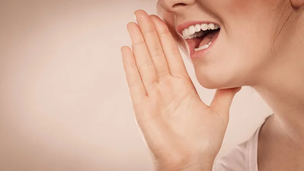 Vrouw praten roddel met de hand dicht bij lippen — Stockfoto