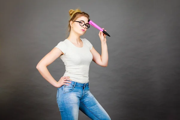 Mujer sosteniendo un gran lápiz de gran tamaño pensando en algo — Foto de Stock