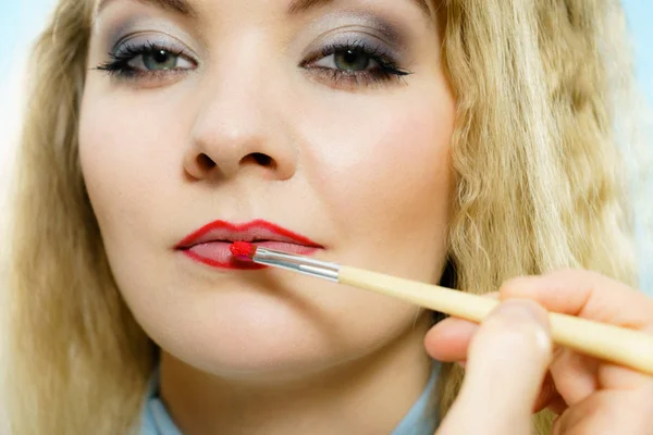 Het aanbrengen van lippenstift op modellippen — Stockfoto