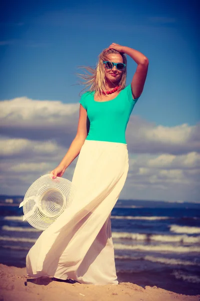 Mujer rubia usando vestido caminando en la playa — Foto de Stock