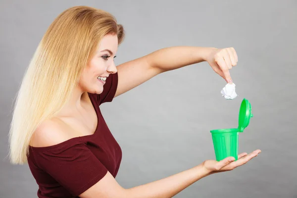 Woman putting paper into small trash can — Stock Photo, Image