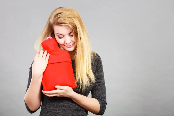 Frau hält warme rote Wärmflasche — Stockfoto