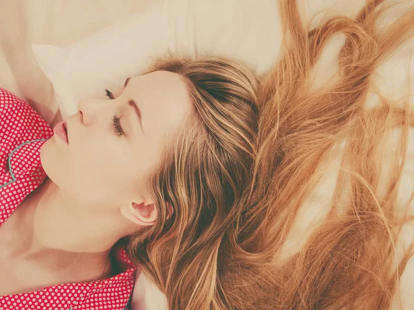 Молодая женщина лежит на кровати в пижаме — стоковое фото