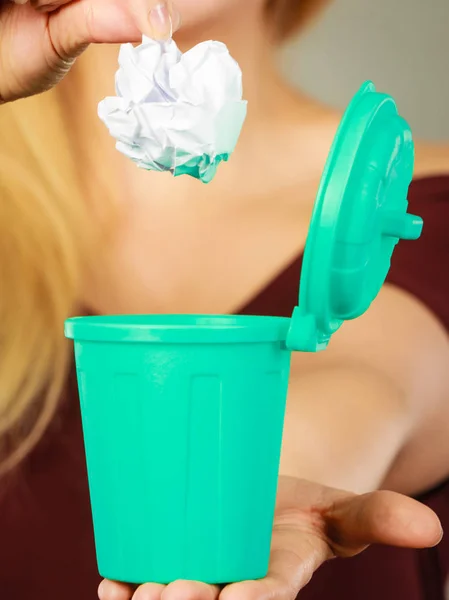 Woman putting paper into small trash can — Stock Photo, Image