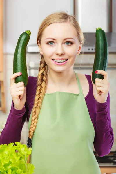 Kobieta w kuchni trzyma cukinia warzyw — Zdjęcie stockowe