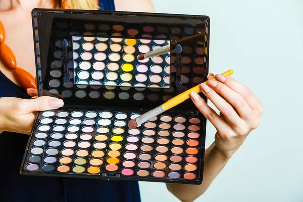 Frau hält Make-up Lidschatten Palette und Pinsel. — Stockfoto