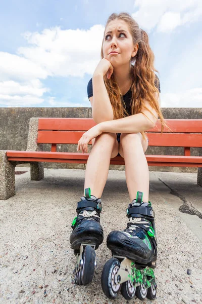 Patinaje sobre ruedas mujer aburrida en el banco — Foto de Stock