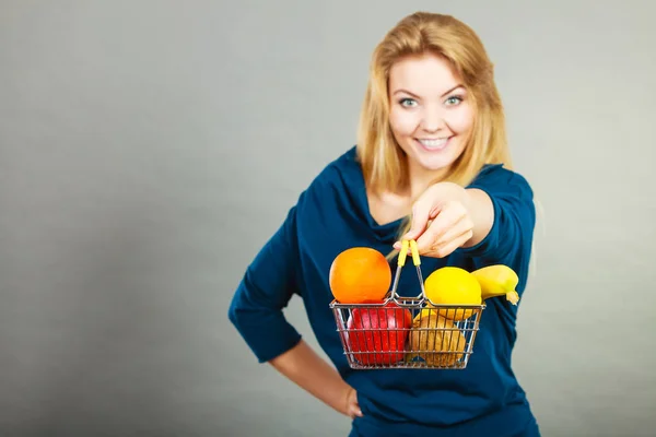 Mujer sosteniendo cesta con frutas en el interior —  Fotos de Stock