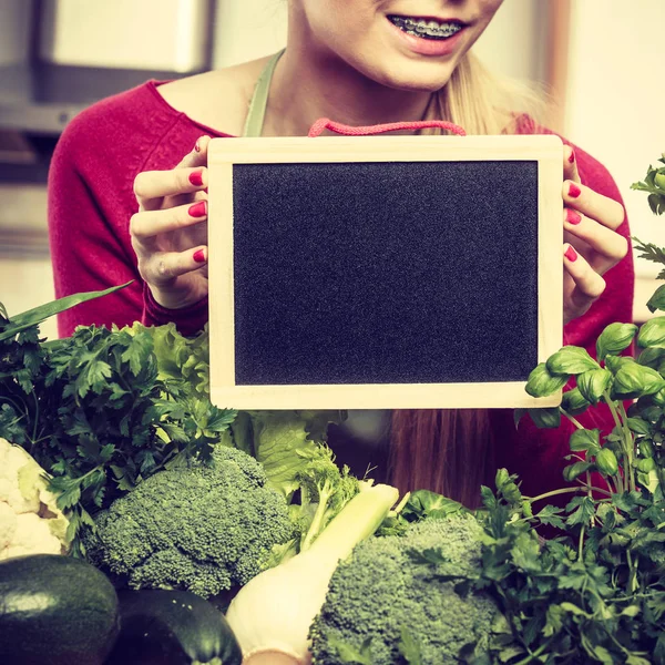 基板を保持している緑の野菜を持つ女性 — ストック写真